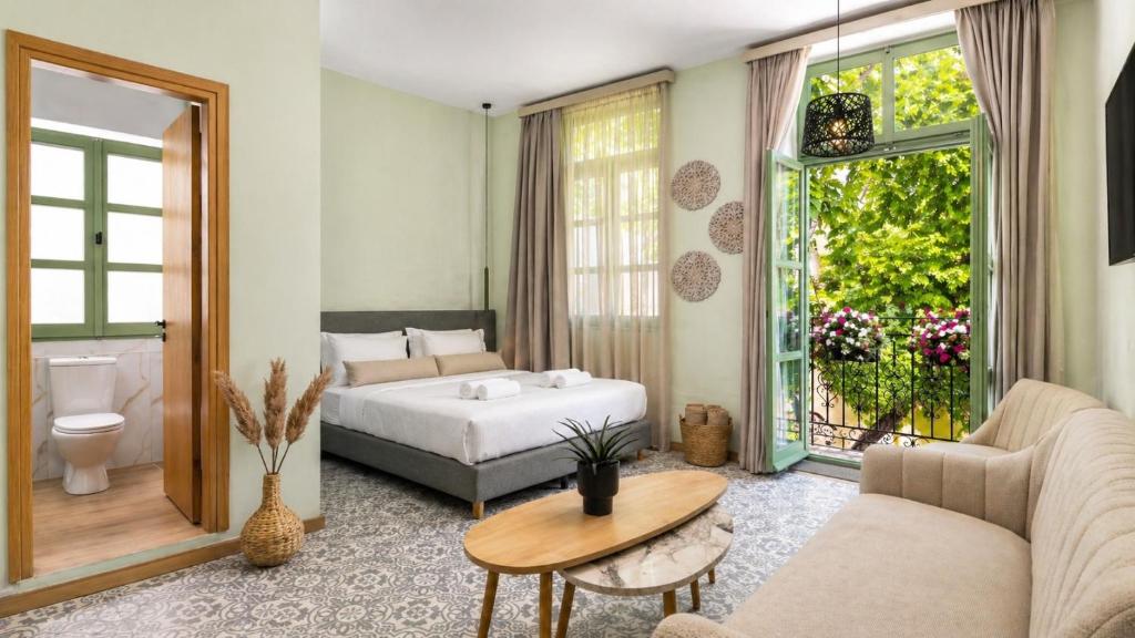 a bedroom with a bed and a couch and a table at Aurelia Boutique - Suites in Rhodes Town