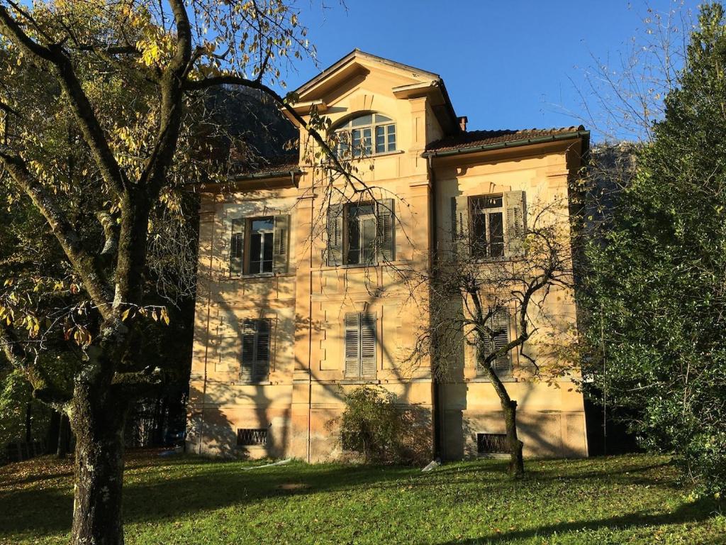 an old stone house with a tree in front of it at Apartment in Historic Villa in Faido