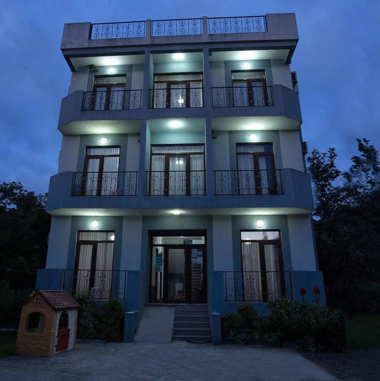 a tall blue building with lights on it at Salo Pool Hotel by the Sea in Gonio