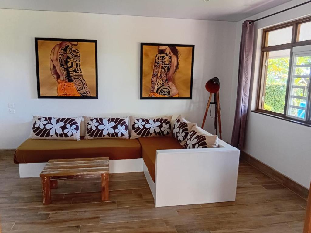 a living room with a couch and a table at Hiro'a - Fare Orotia in Taputapuapea