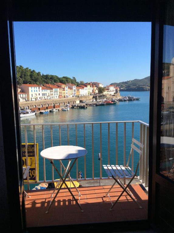 Habitación con vistas a un balcón con mesa y sillas. en Un Balcon Sur La Mer, en Port-Vendres