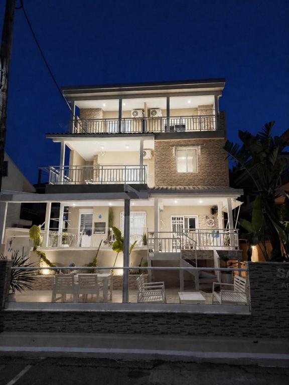a large white building with a balcony at night at Sammys apartments in Nea Potidaea