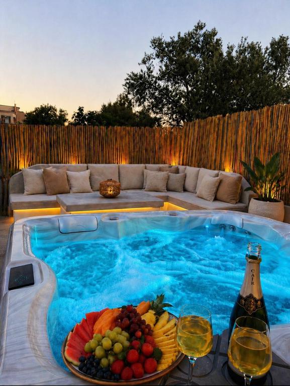 a swimming pool with a plate of fruit and wine glasses at Diamond Rod Villa near Faliraki in Kalithies