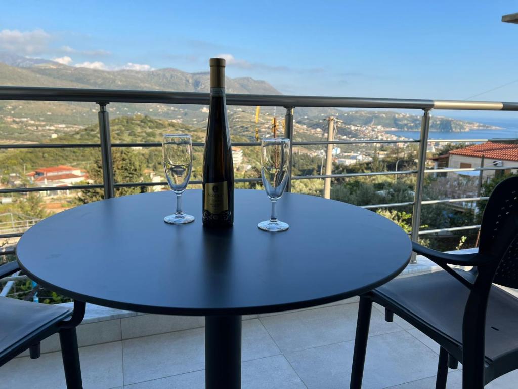 a bottle of wine and two glasses on a table at Irene's rooms in Himare