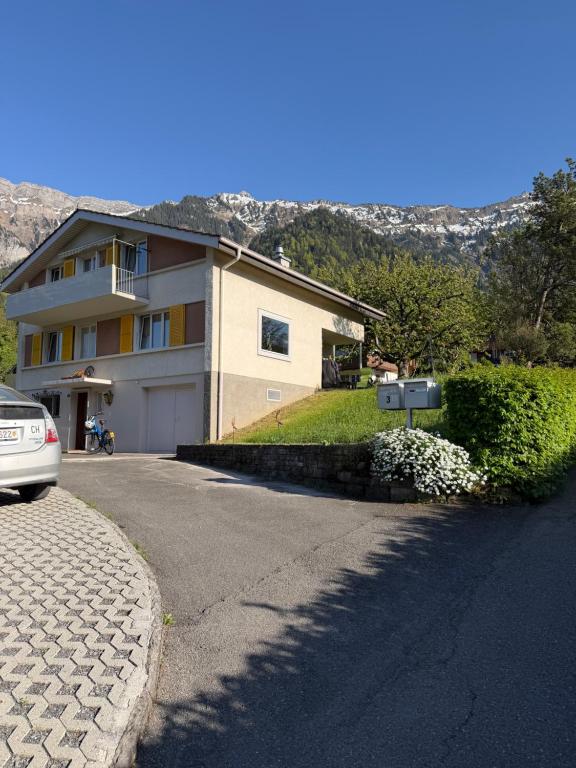 a house with a car parked in front of a driveway at Mountain and Lake in Bönigen