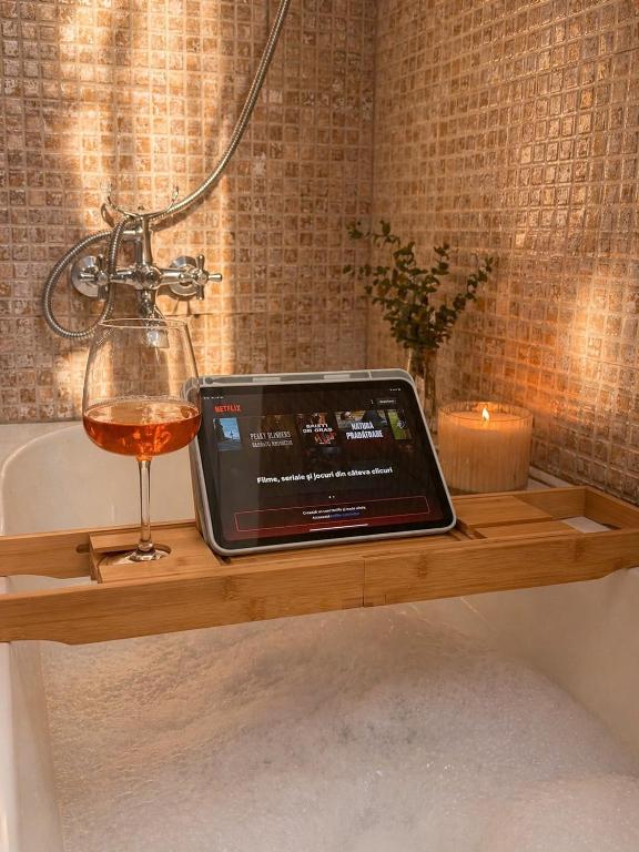 a tablet sitting on a wooden shelf next to a glass of wine at DG - Urban Stay in Floreşti