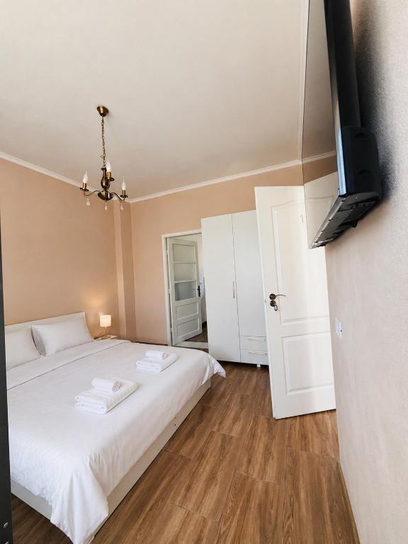 a bedroom with a white bed and a flat screen tv at Casa Andra in Drobeta-Turnu Severin
