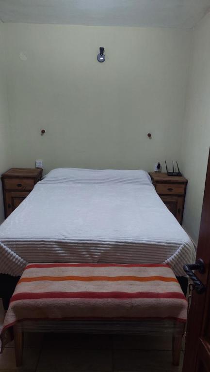 a bedroom with a bed and two dressers at Tinkunaco in Purmamarca