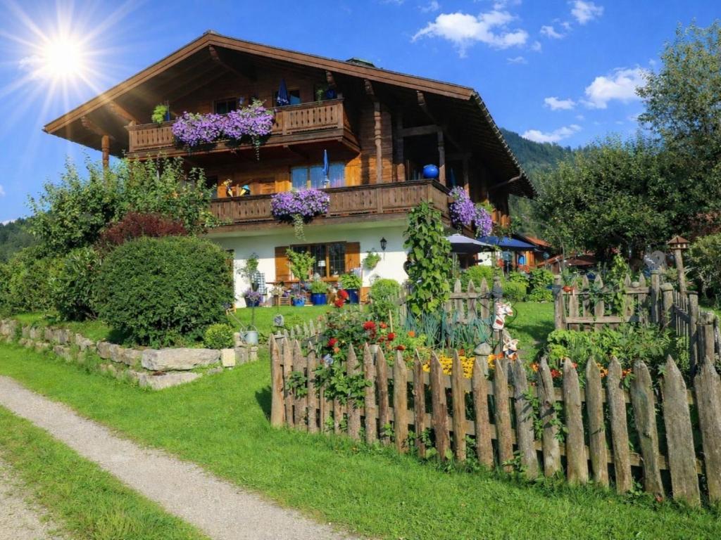 a house with a wooden fence in front of it at Gästehaus Schönfeld in Reit im Winkl