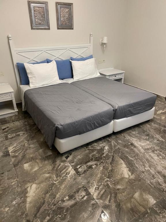 a bedroom with a large bed with blue and white pillows at Dionisia Apartments in Kefalos