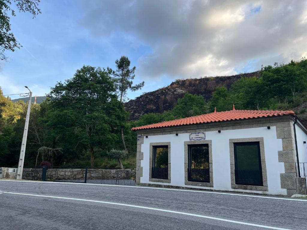 a small white building on the side of a road at Casa De Cantoneiros in Campos