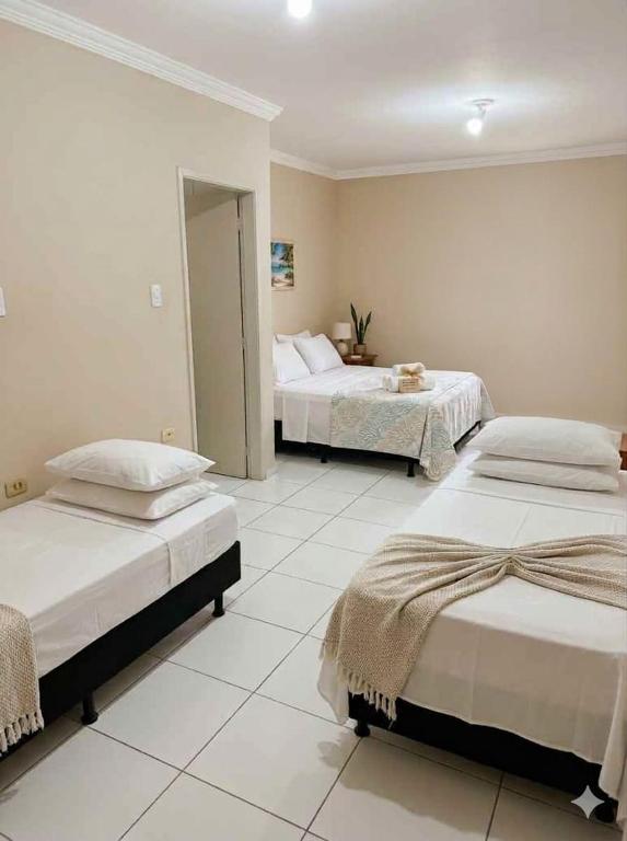 a bedroom with two beds and a room with two at Kairos Pousada e Hostel in Cabo de Santo Agostinho