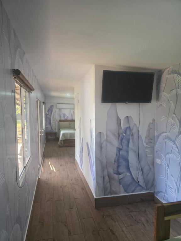a hallway with a wall with a flat screen tv at Harvestmoon Boutique Hotel in Las Piedras
