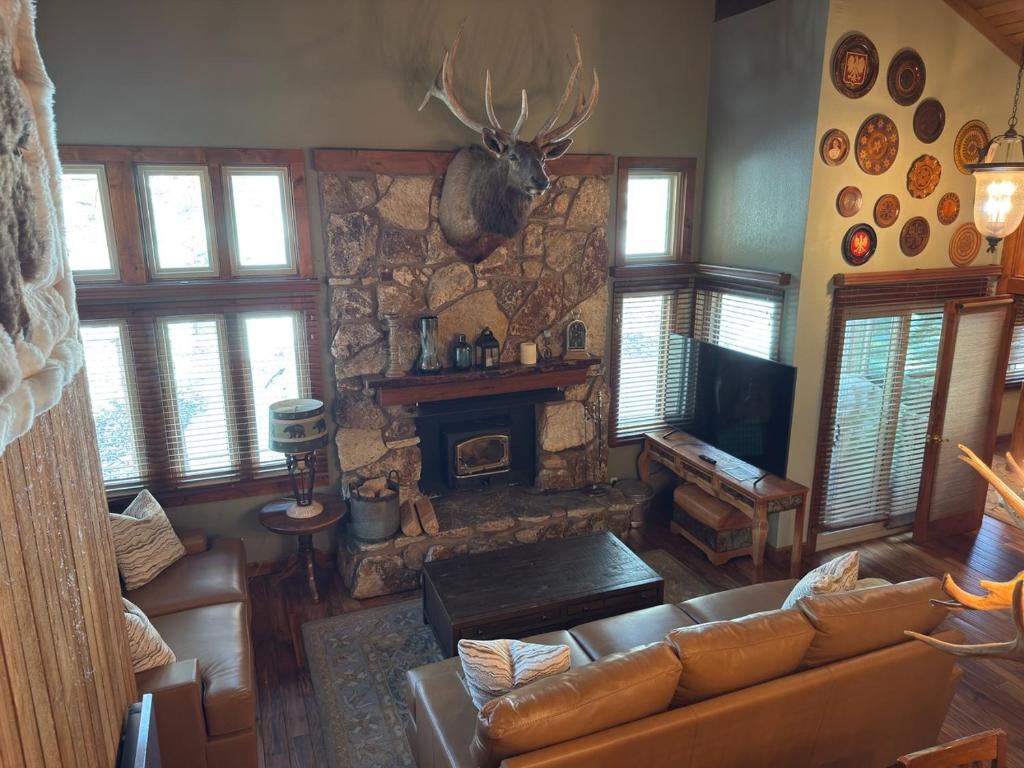 a living room with a couch and a stone fireplace at Mountainback 79 Loft Den in Mammoth Lakes