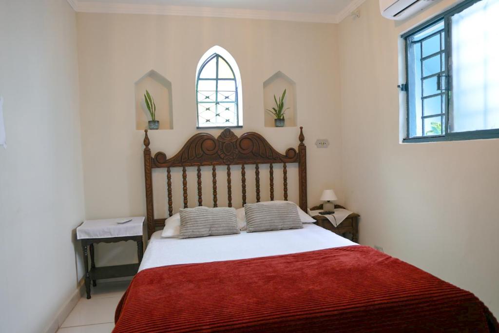 a bedroom with a large bed with a red blanket at Hostel Castell Di Madre in Santos