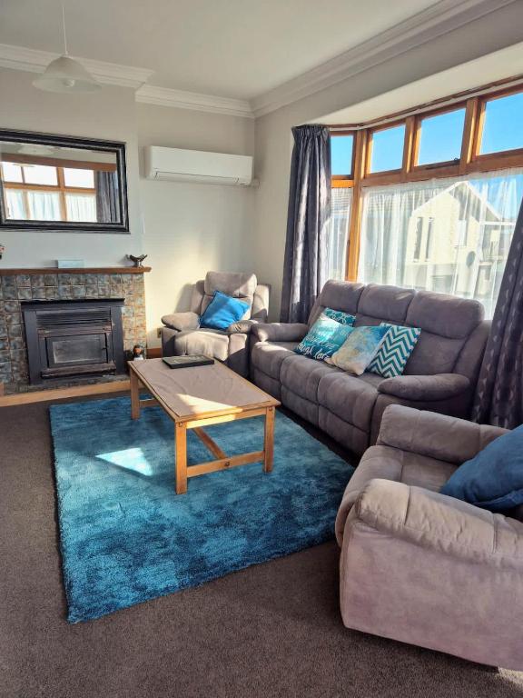 a living room with a couch and a coffee table at Cosy On Till in Oamaru