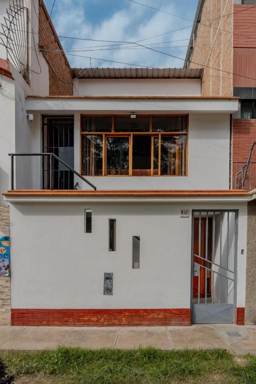 a white house with a lot of windows at Monoambiente 101 in Trujillo