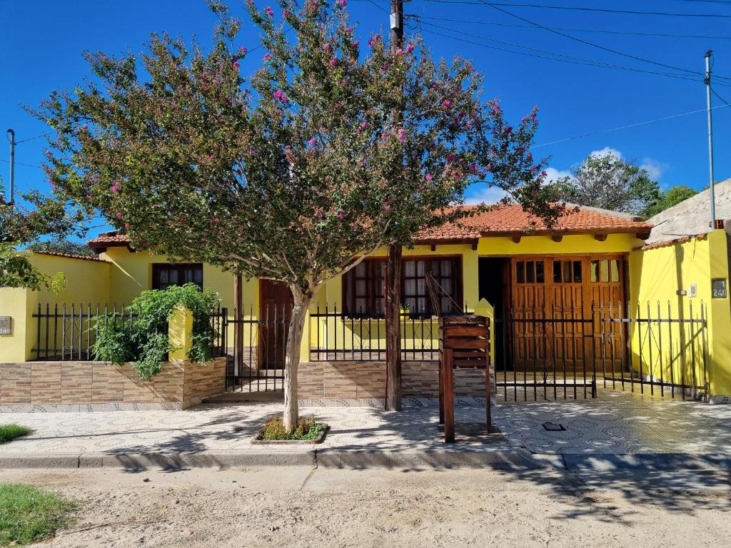 a yellow house with a tree in front of it at CASA Costanera in Cafayate