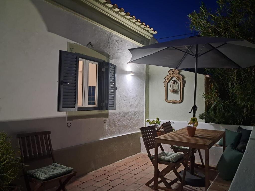 a table and chairs with an umbrella on a patio at Monte da ti Luzia in Faro