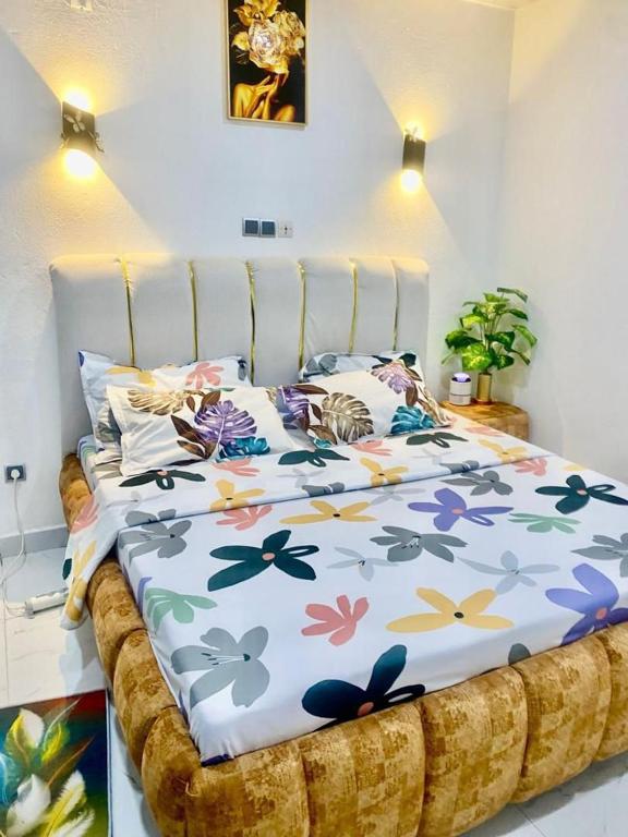 a bed with a floral bedspread on it in a room at CHAMBREs SALON MEUBLÉ HD in Yamoussoukro