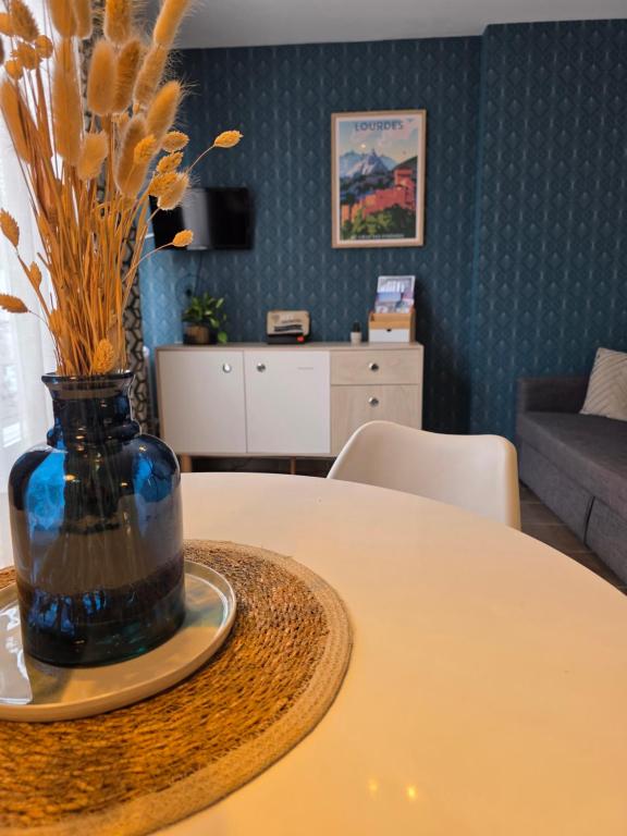 a vase with flowers on a table in a living room at Albatros in Lourdes