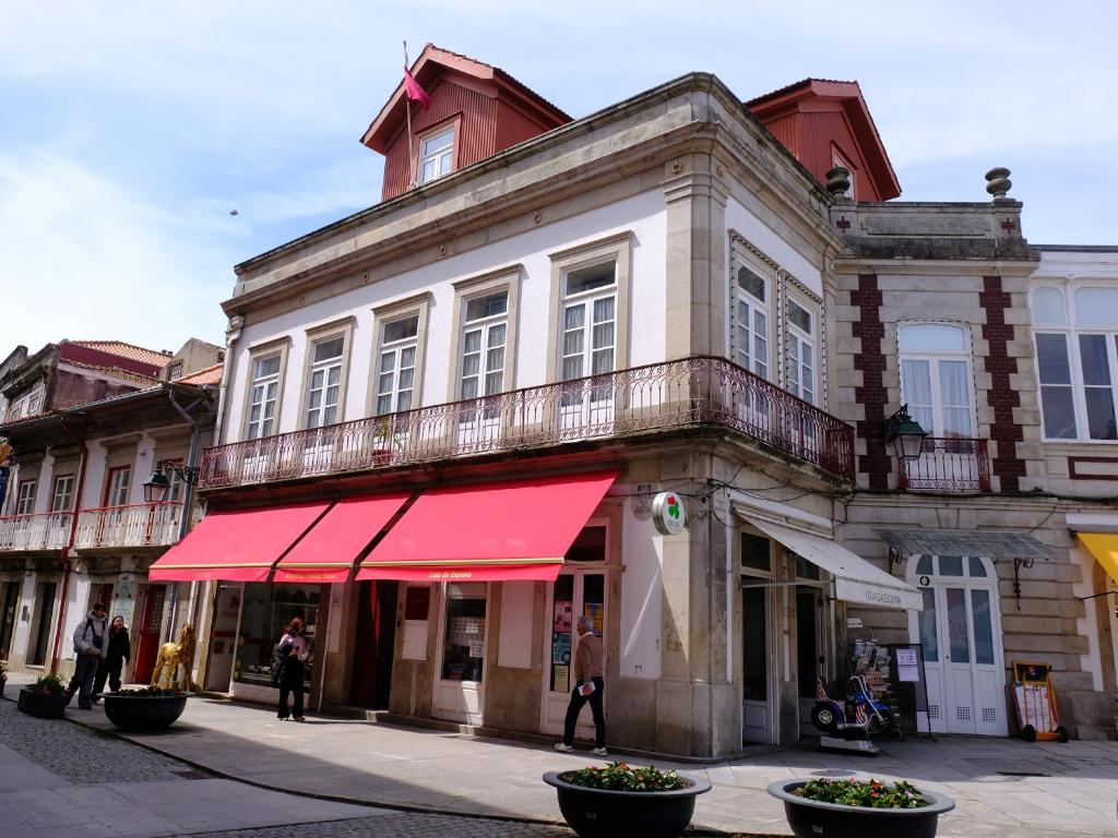 an old building with a red awning on a street at Republica Vintage House in Viana do Castelo