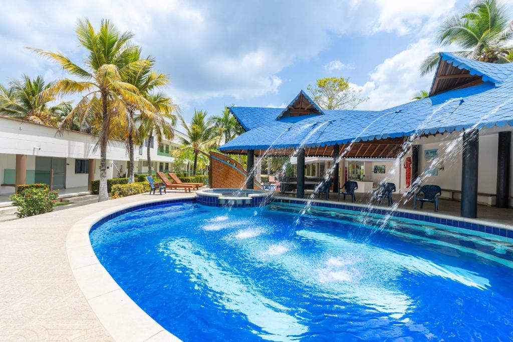 a swimming pool with a fountain in front of a house at Cabañas La Fragata Coveñas in Coveñas