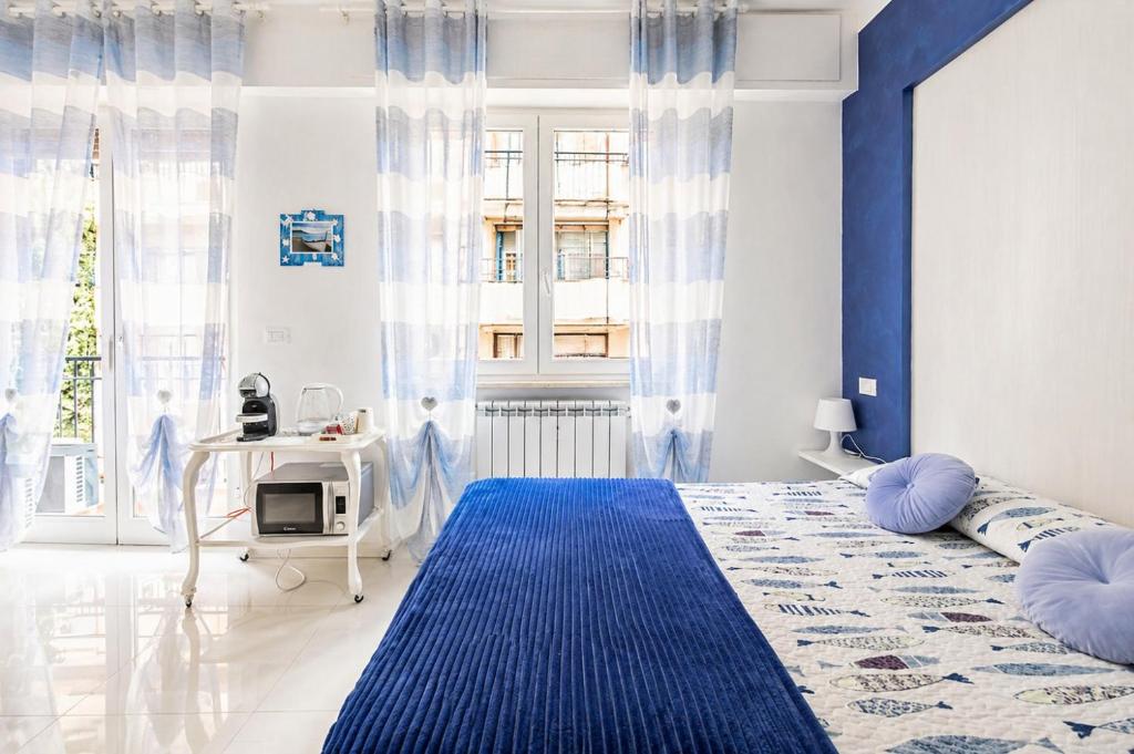 a blue and white bedroom with a bed and a desk at Blu Marina Alassio in Alassio