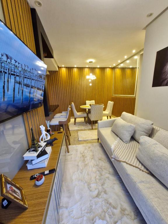 a living room with a couch and a flat screen tv at Apartamento Confortável in Ananindeua