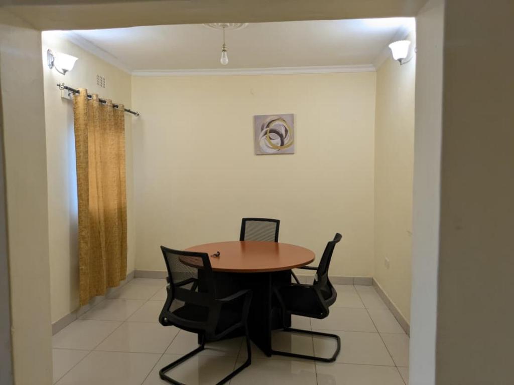 a dining room with a table and two chairs at Rehoboth Area 49 Guest House in Lilongwe