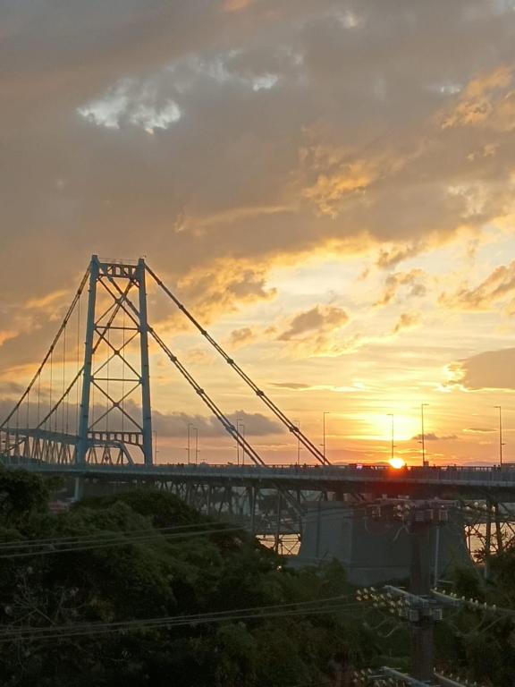 a bridge over a river with the sunset in the background at Guest House Central in Florianópolis
