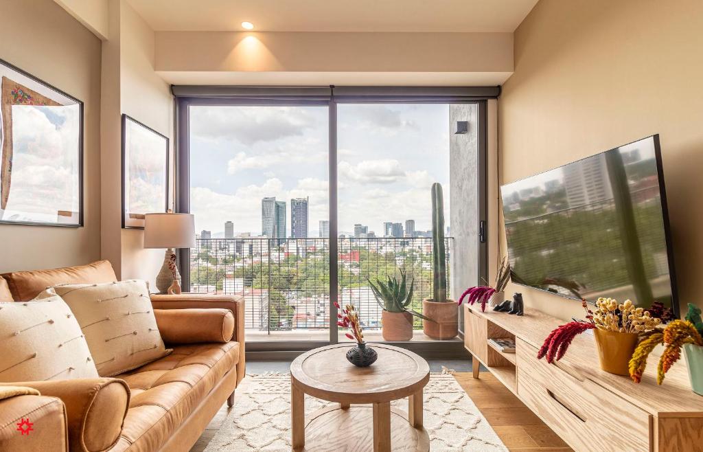 a living room with a couch and a large window at Casa Taman by Kukun in Mexico City