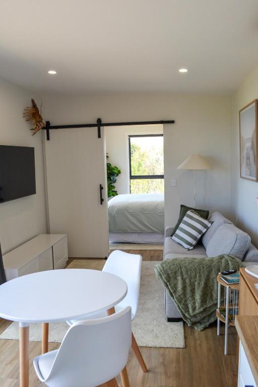 a living room with a bed and a table at Tūhua View Retreat in Waihi Beach