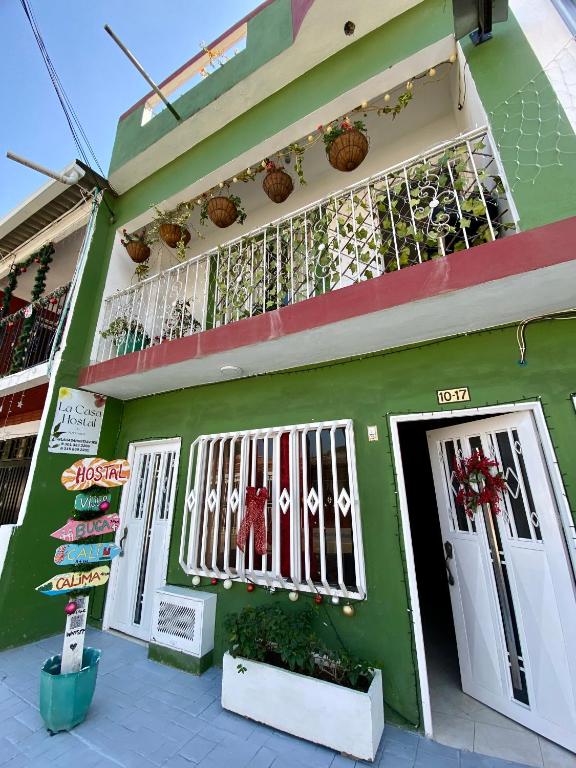 a green building with a balcony on it at La Casa Hostal Vijes in Vijes