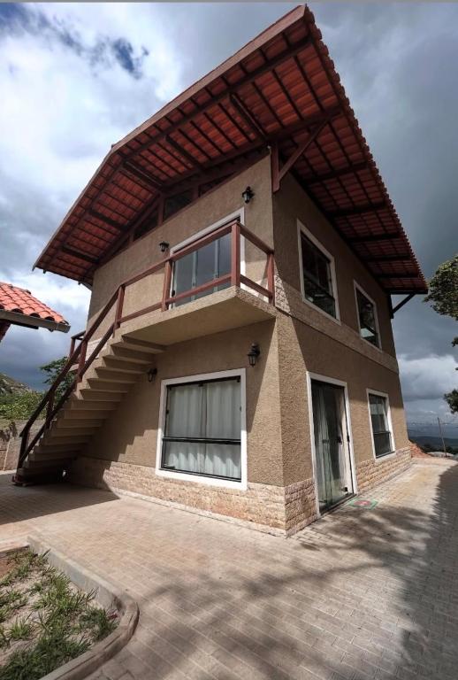 a house with a balcony on top of it at Estação Serra Negra in Bezerros