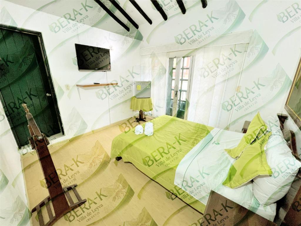 a bedroom with a guitar and a bed and a television at Hotel Bera-k in Villa de Leyva