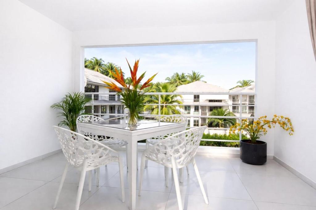 a white dining room with a white table and chairs at L' É'sens Karaïbes in Les Abymes