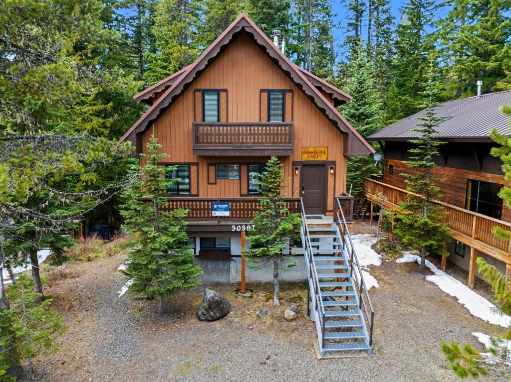 a log cabin with a staircase leading to the front door at Snowflake Chalet in Government Camp
