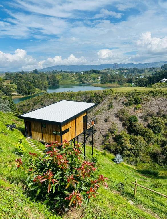 a small house on a hill with a lake at Cabaña Monte cristo in Guatapé