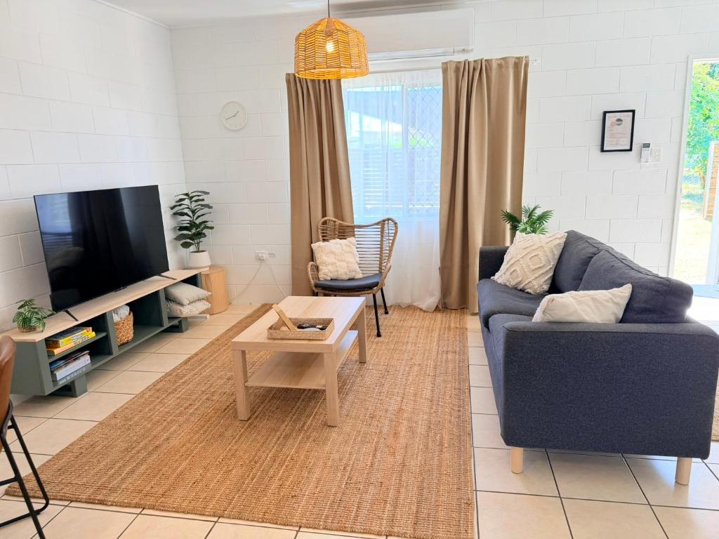 a living room with a blue couch and a tv at 'Your Place on Davidson' in Mount Isa
