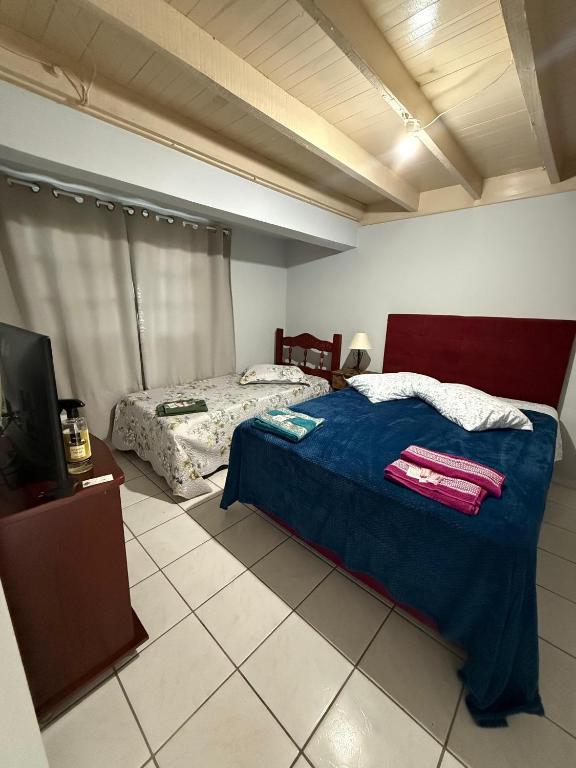 a bedroom with a bed and a television in it at Casa Miguel in Lauro Müller
