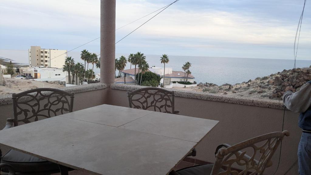 a table and chairs on a balcony overlooking the ocean at Whale Hill Escape - Beach Views and Walk to Mannys in Puerto Peñasco
