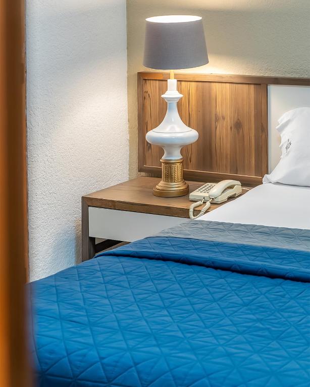 a bedroom with a bed and a lamp on a desk at Hotel Mariscal in Mexico City