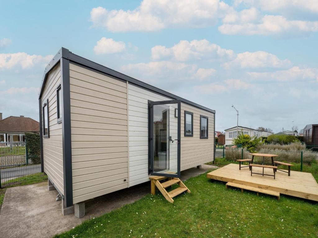 a tiny house with a table and a bench at Berlare Retreat for 6 with garden in Berlare