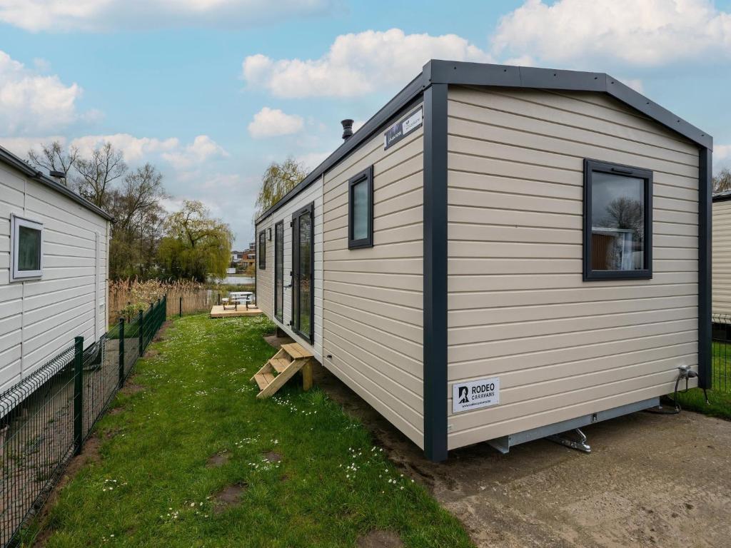 a tiny house is parked in a yard at Cozy Caravan in Berlare for 6 people in Berlare