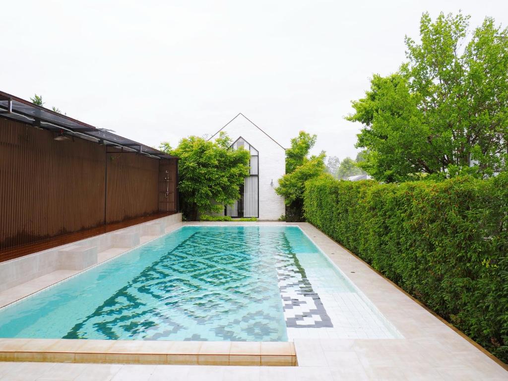a swimming pool in the backyard of a house at Phuping Valley Resort in Tak