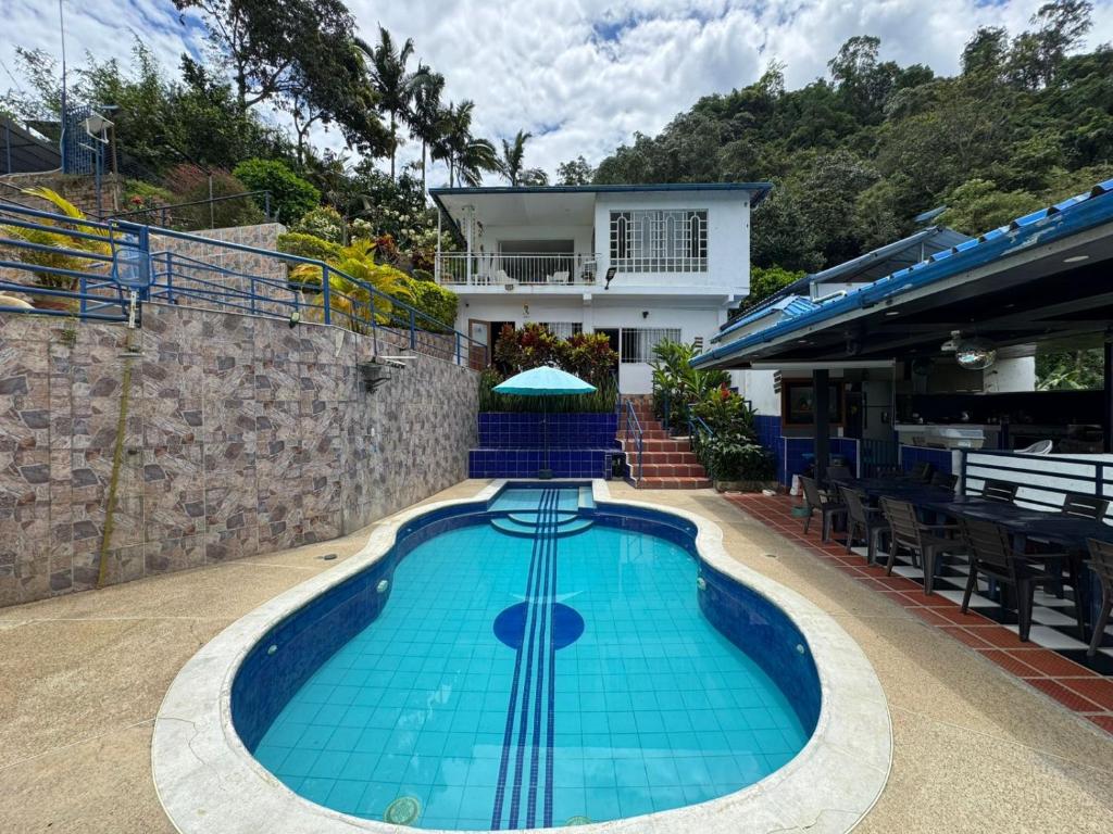 a swimming pool in front of a house at Finca Altamira in La Vega