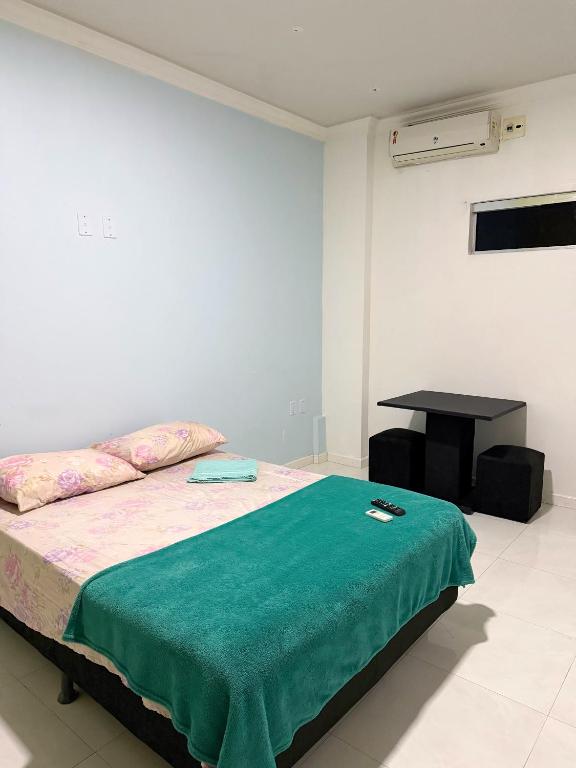 a bedroom with a bed and a table in it at Quarto privado próximo ao centro 3 in Manaus