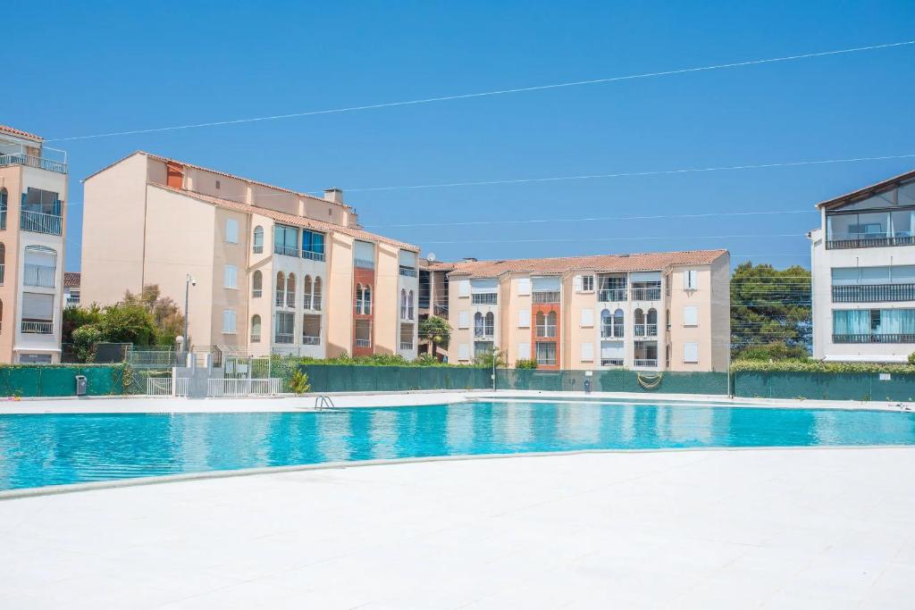 an empty swimming pool with buildings in the background at Moréa - residence avec piscine in Fréjus