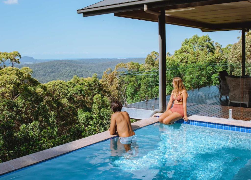 a man and a woman sitting in a swimming pool at Wilderness House in Kulangoor